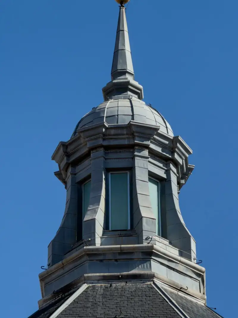 Elegant architectural spire in Madrid, showcasing intricate design against a clear blue sky.