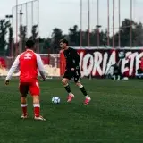 Soccer players in action during an outdoor training session on a green field.