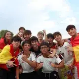 Un grupo de entusiastas aficionados del fútbol español celebrando al aire libre en Madrid.