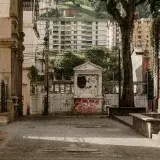 Quiet urban alley in Mérida, Venezuela, with historic architecture and lush greenery.