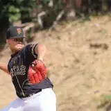 A focused baseball player pitching during a sunny outdoor game.