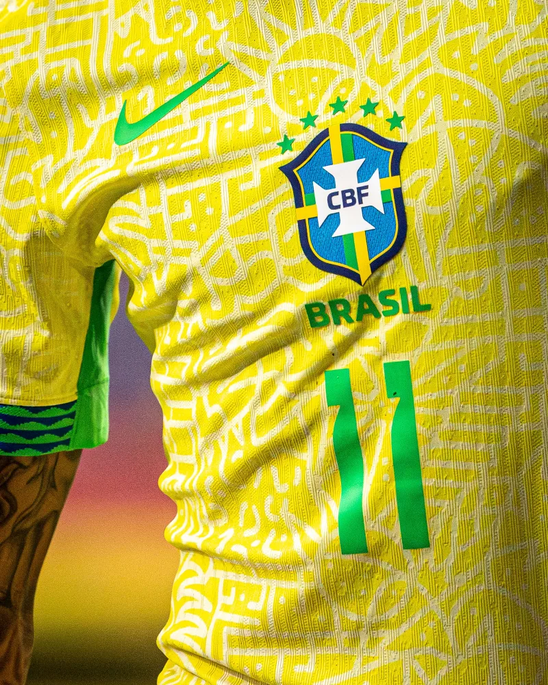 Detailed shot of a Brasil national football team's yellow jersey featuring emblem and number 11.