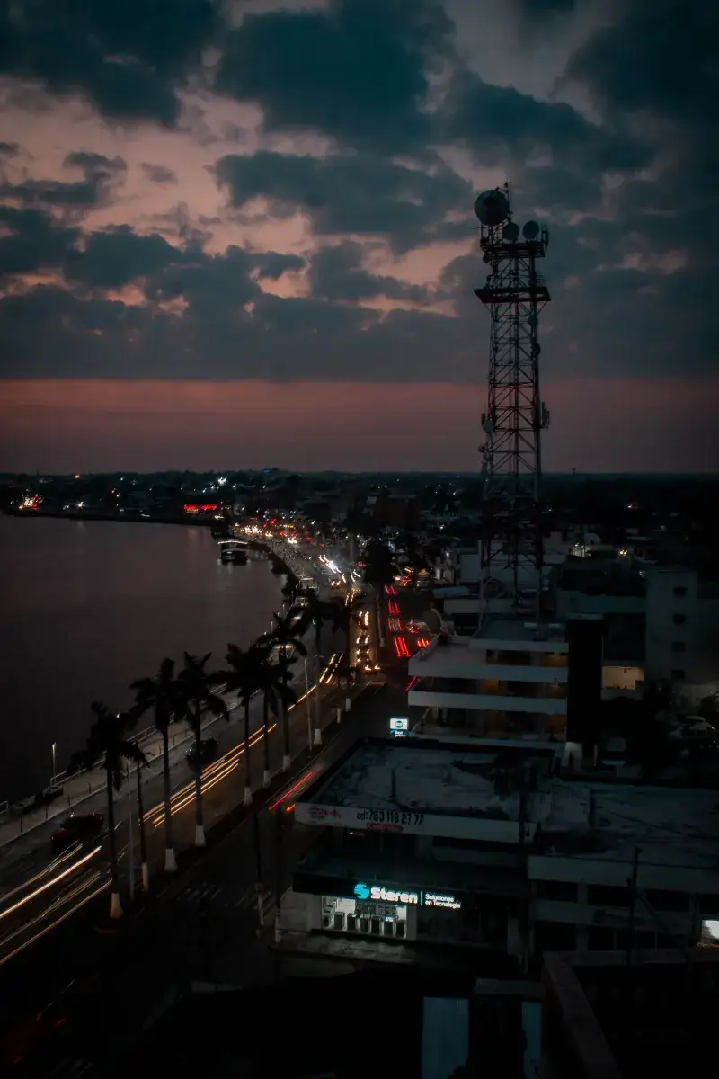 Aerial view of Túxpam de Rodríguez Cano, Mexico at dusk with vibrant streetlights and cityscape.
