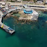 Aerial photograph of Algarrobo pier with fishing boats and coastal buildings, showcasing the vibrant coastal scene in Chile.