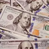 Foto de alta resolución de billetes de cien dólares estadounidenses dispuestos, mostrando a Benjamin Franklin.