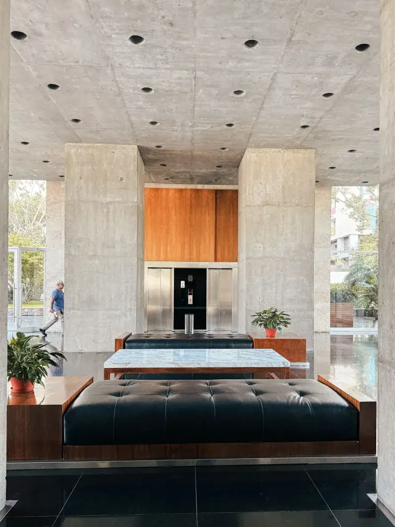 Lobby contemporáneo con muebles modernos y plantas en un edificio de Buenos Aires.