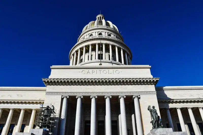 Low angle view of the iconic El Capitolio building under a clear blue sky in Havana, Cuba.