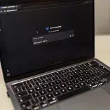 Close-up of a laptop showing an AI chat interface in a dimly lit room.
