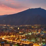 A stunning aerial view of Caracas cityscape at dusk, showcasing the vibrant city lights against the mountainous backdrop.
