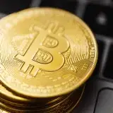 Close-up image of Bitcoin coins stacked on a laptop keyboard, symbolizing digital currency and blockchain technology.
