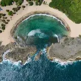 Stunning aerial view of Playa Mar Chiquita's turquoise waters and rocky coastline in Puerto Rico.