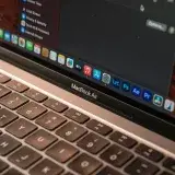 Vista detallada de un MacBook Air con enfoque en el teclado y la pantalla que muestra iconos de aplicaciones.