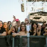 Festival attendees joyfully capturing the live concert experience with smartphones.
