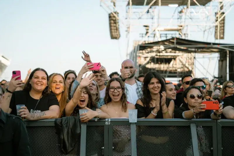Festival attendees joyfully capturing the live concert experience with smartphones.