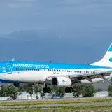 Avión de Aerolíneas Argentinas aterrizando frente a un fondo montañoso en Argentina.