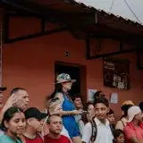 A lively crowd gathers outside a building on a busy city street. Diverse group enjoying a community event.