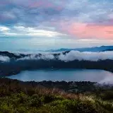 Majestic sunset over Santa María del Oro Lake with colorful clouds and lush greenery.