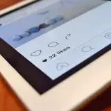 Photo of a tablet displaying a social media app interface with 22 likes, highlighting digital interaction.