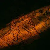 Close-up vintage map of South America illuminated by warm, artistic lighting giving a historical feel.