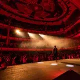 Live performance at Teatro de la Ciudad, Mexico City, with a dynamic audience and performers on a red-lit stage.