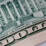From above ten dollar banknote with inscription and United States treasury building placed on table