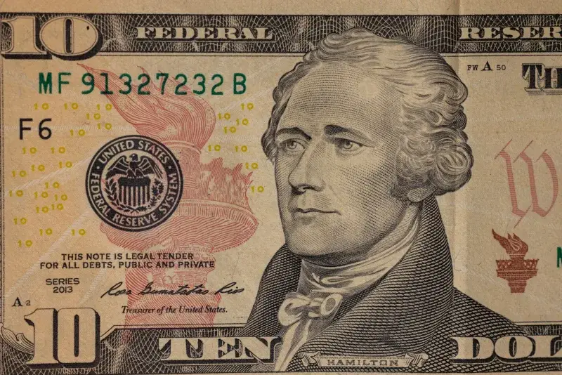 Detailed close-up image of a US ten dollar bill with Alexander Hamilton's portrait.