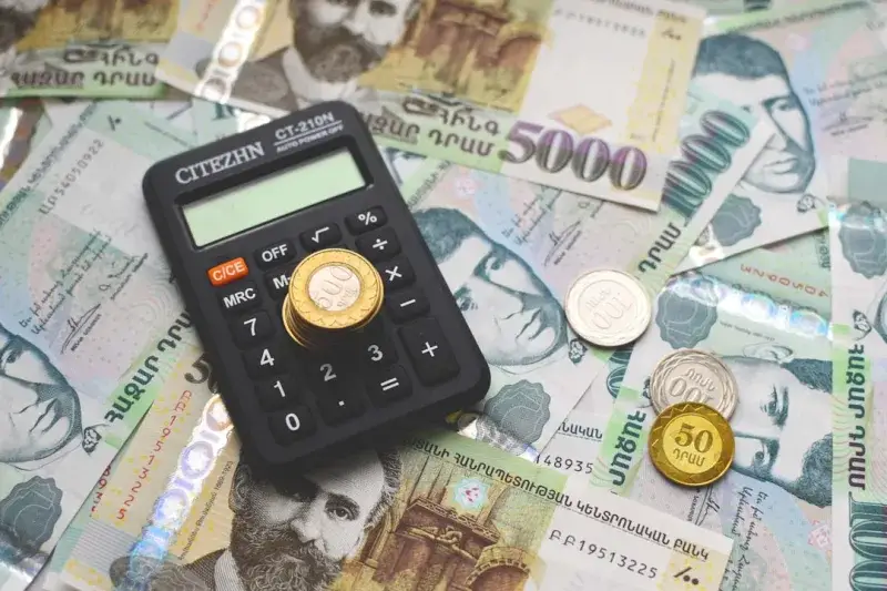 Armenian paper money banknotes and coins and calculator on the table.
