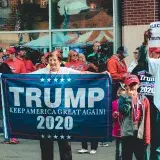 A crowded political rally in Wheeling, showcasing Trump supporters with banners and signs.